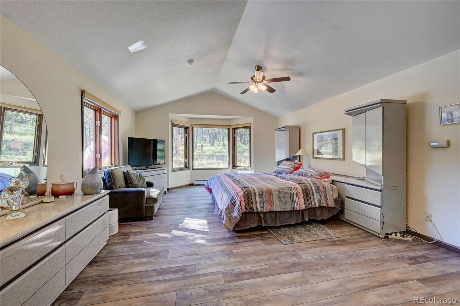 411 Spring Drive Pine, CO 80470 - Photo 31 of 40 a spacious bedroom with a large bed and a couch