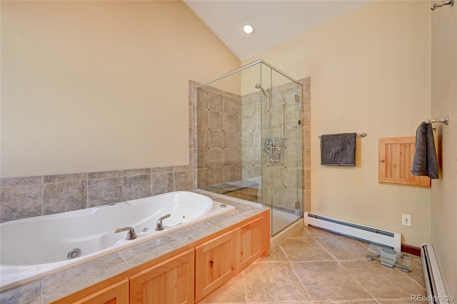 411 Spring Drive Pine, CO 80470 - Photo 34 of 40 a bathroom with a tub a sink and a shower