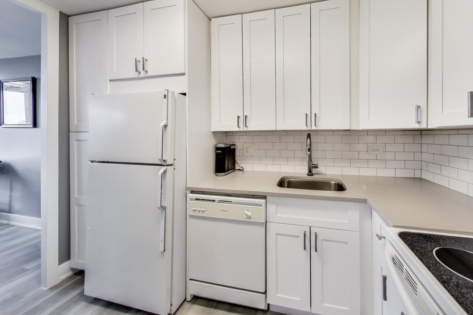 655 West Irving Park Road, Unit 814 Chicago, IL 60613 - Photo 11 of 34 a kitchen with white cabinets and white appliances