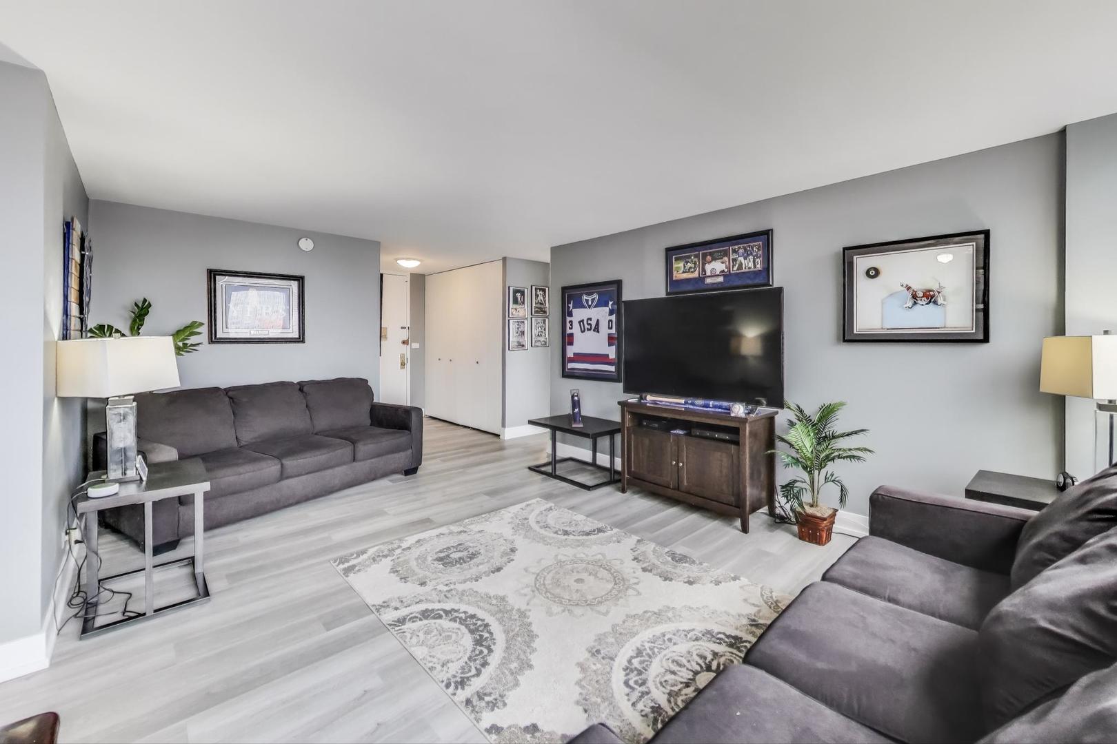 655 West Irving Park Road, Unit 814 Chicago, IL 60613 - Photo 6 of 34 a living room with furniture and a flat screen tv