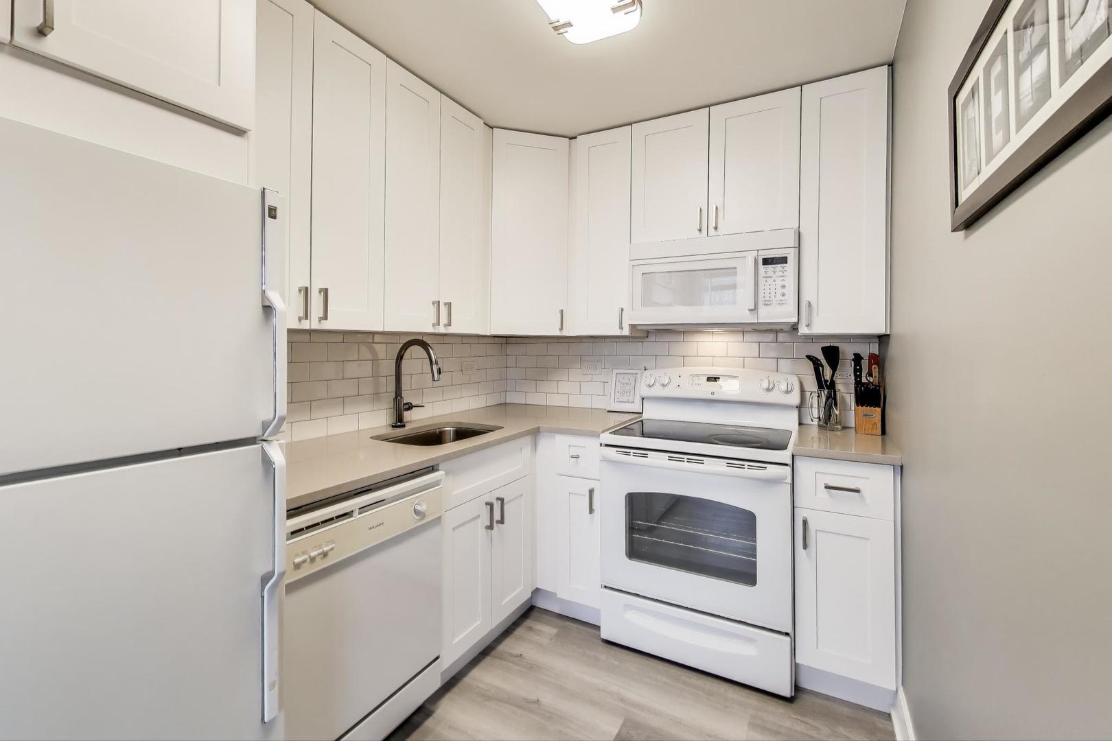 655 West Irving Park Road, Unit 814 Chicago, IL 60613 - Photo 10 of 34 a kitchen with stainless steel appliances granite countertop white cabinets sink and white stainless steel appliances