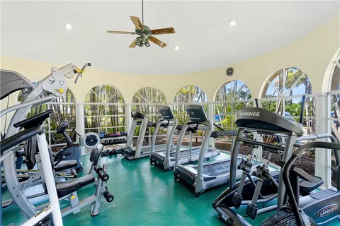 a room with lots of white furniture and a chandelier
