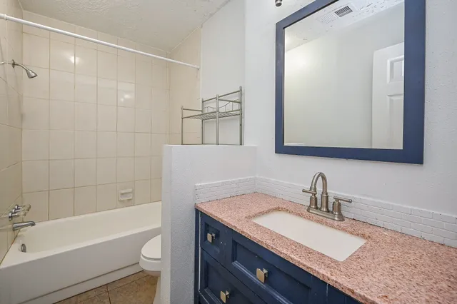 a bathroom with a granite countertop sink toilet and shower
