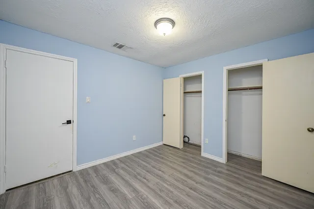 an empty room with wooden floor and closet