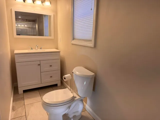 a bathroom with a toilet sink and mirror