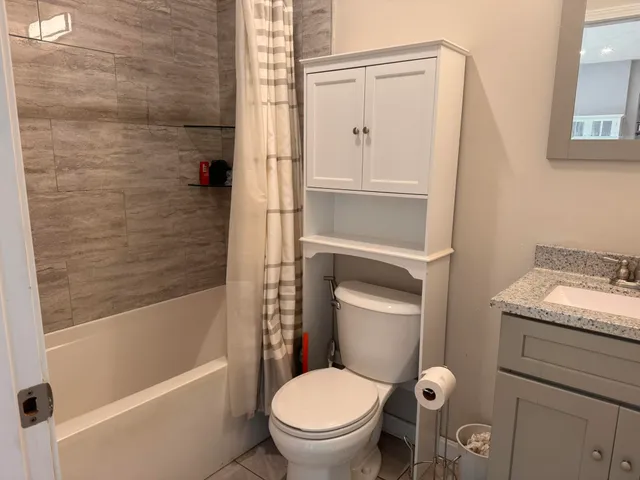a bathroom with a granite countertop toilet a sink and bathtub
