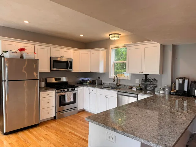 a kitchen with stainless steel appliances granite countertop a stove a sink dishwasher a refrigerator and a microwave