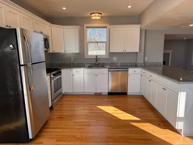 a kitchen with stainless steel appliances granite countertop a sink stove and refrigerator