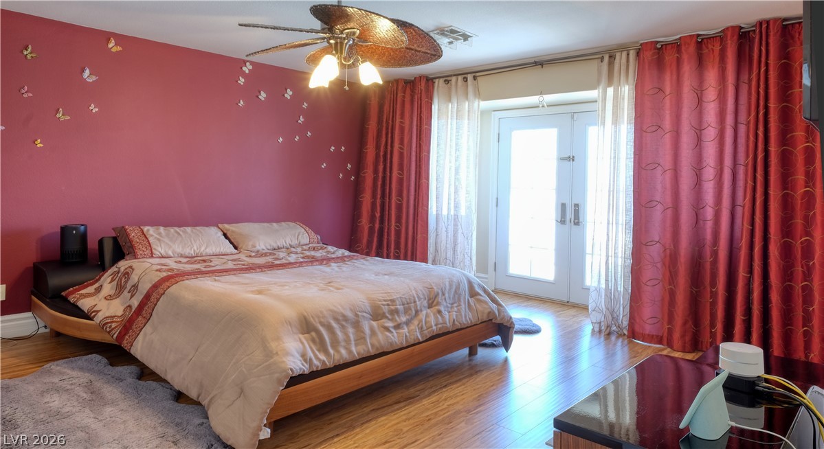 3704 North Campbell Road Las Vegas, NV 89129 - Photo 34 of 46 Hardwood floors and a spacious double door entry provide comfort in this restful primary bedroom.