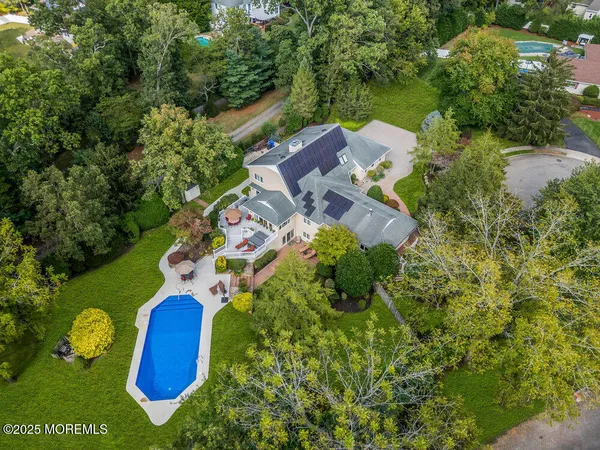 an aerial view of a house with swimming pool and garden space