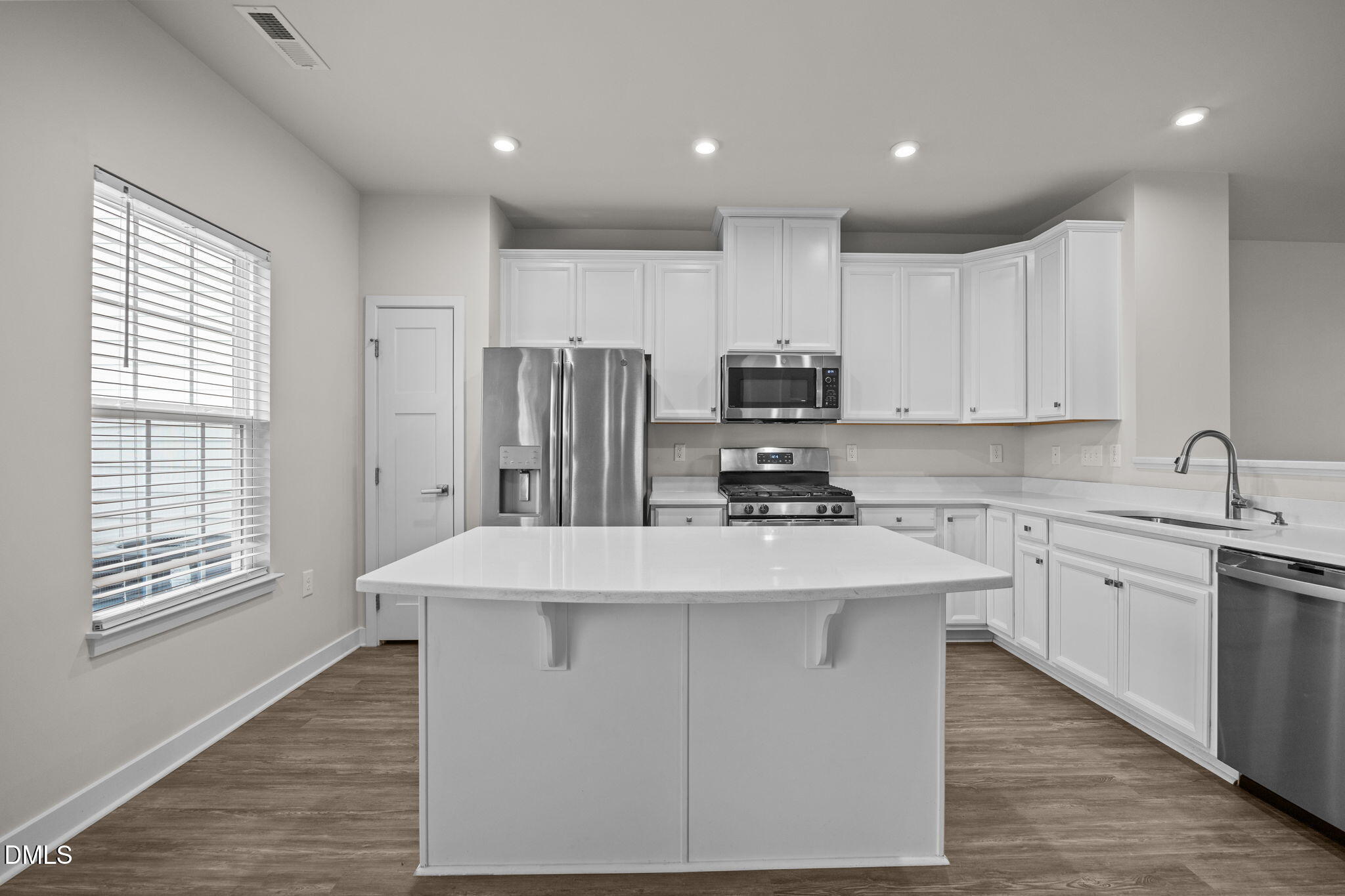 945 Anthem Lane Durham, NC 27713 - Photo 5 of 51 a kitchen with kitchen island stainless steel appliances sink refrigerator microwave and cabinets