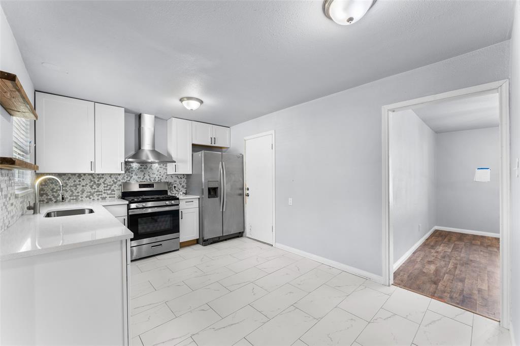 612 East 8th Street Kemp, TX 75143 - Photo 12 of 25 Modern kitchen featuring white cabinetry, stainless steel appliances, and a mosaic tile backsplash