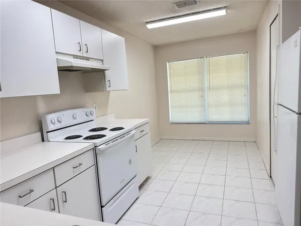 a kitchen with granite countertop white cabinets and white appliances