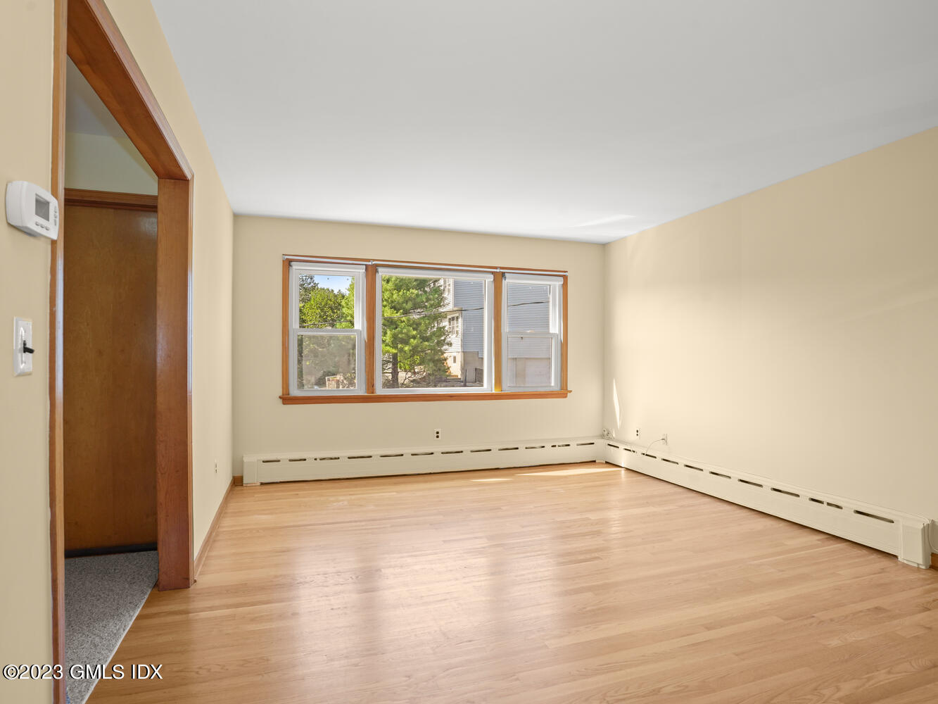 63 Cos Cob Avenue, Unit B Cos Cob, CT 06807 - Photo 4 of 14 a view of an empty room with a window and wooden floor