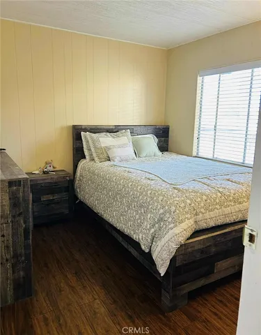 a bedroom with a bed table and a window
