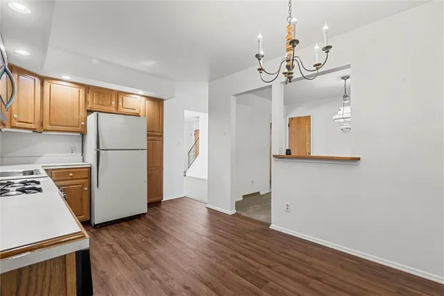 a view of a kitchen with a refrigerator a ceiling fan and wooden floor