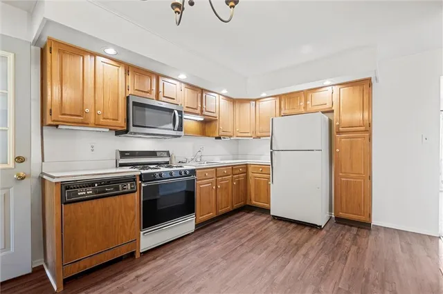 a kitchen with a refrigerator stove and wooden cabinets