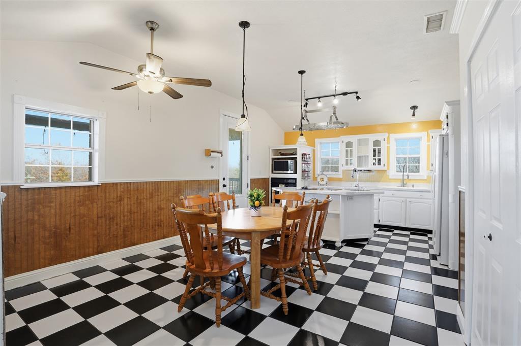 5824 Sky Road Joshua, TX 76058 - Photo 12 of 40 a dining room with a black white checkered floor with a dining table and chairs