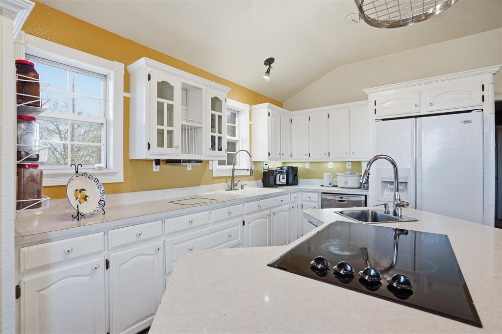 5824 Sky Road Joshua, TX 76058 - Photo 13 of 40 a kitchen with a sink a stove and white cabinets