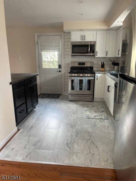 1409 River Road Belmar, NJ 07719 - Photo 6 of 22 a kitchen with stainless steel appliances a stove a sink a microwave a refrigerator a cabinets