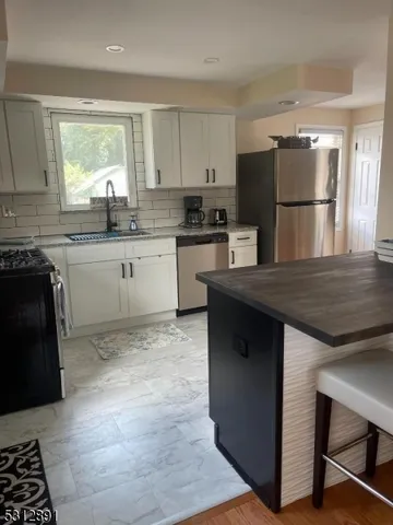 a kitchen with a refrigerator and a stove top oven
