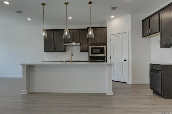 a large kitchen with stainless steel appliances granite countertop a refrigerator a oven a sink and a microwave