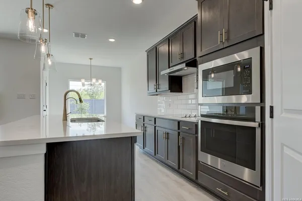 a kitchen with stainless steel appliances granite countertop a stove and a microwave