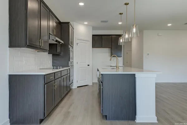 a kitchen with kitchen island granite countertop a sink stainless steel appliances and cabinets
