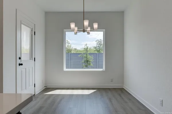a view of a room with wooden floor a ceiling fan and window