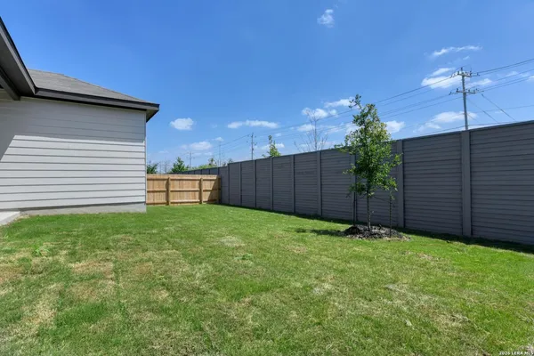 a view of a backyard with potted plants and wooden fence