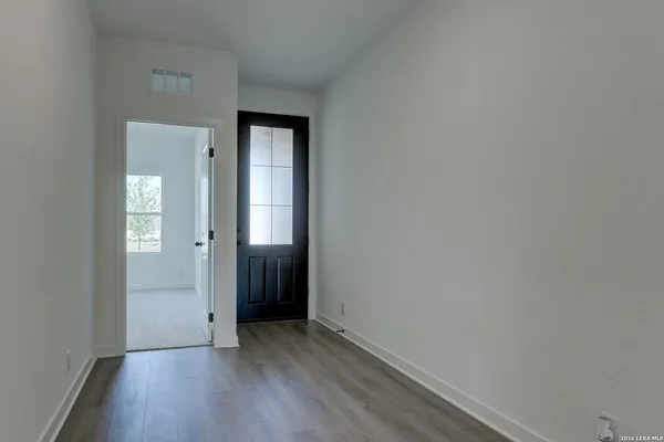 a view of an empty room with closet and mirror
