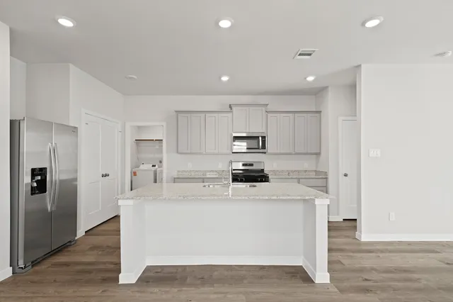 a kitchen with stainless steel appliances a sink stove and refrigerator