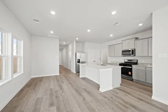 a kitchen with white cabinets and stainless steel appliances
