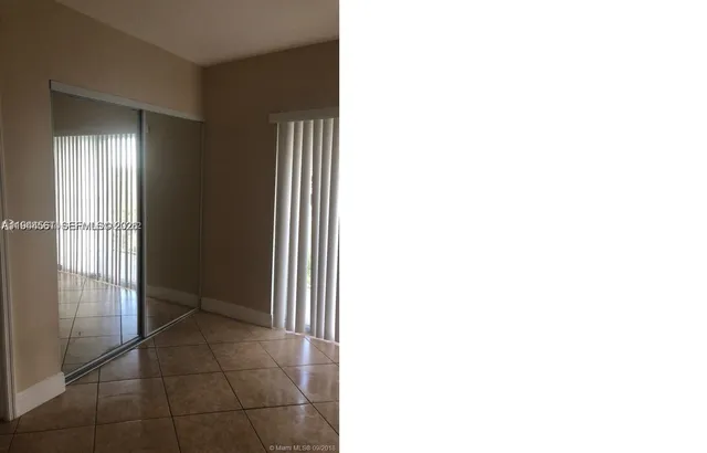 a view of an empty room with floor and a window