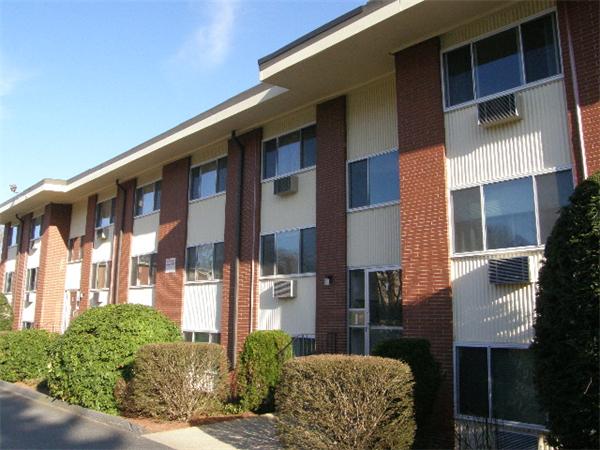 74 Beach Street, Unit 12 Woburn, MA 01801 - Photo 2 of 8 a front view of a building with a garden