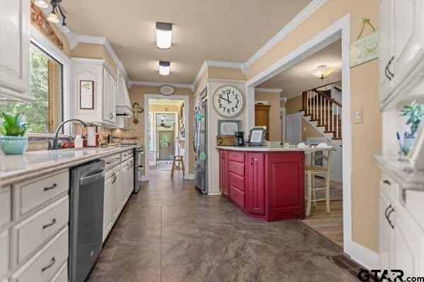 a large kitchen with a lot of counter space and stainless steel appliances