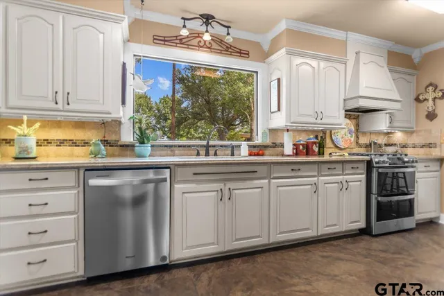a kitchen with stainless steel appliances granite countertop white cabinets a sink and dishwasher with wooden floor