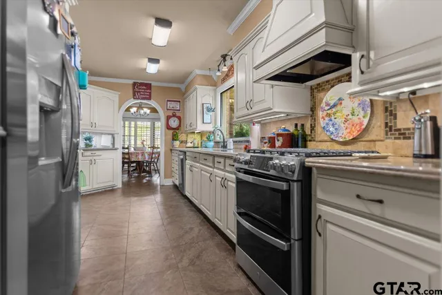 a kitchen with stainless steel appliances granite countertop a stove and cabinets