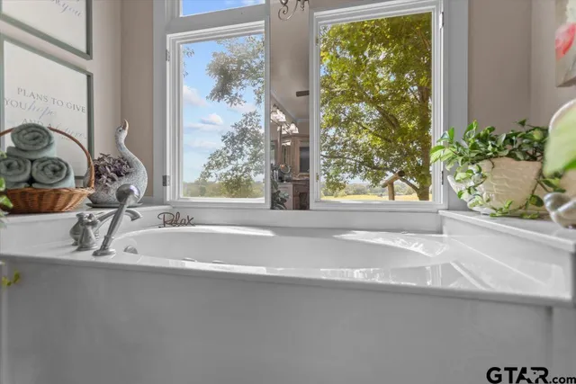 a bathroom with a granite countertop sink and a window