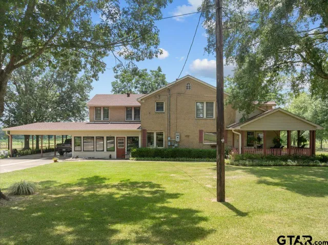 a front view of a house with swimming pool and garden