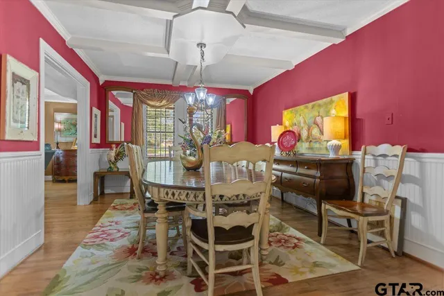 a view of a dining room with furniture a chandelier and wooden floor