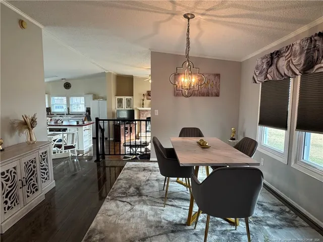 a view of a dining room with furniture and a chandelier