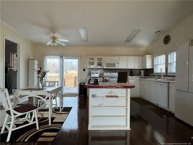 a kitchen with cabinets and chairs