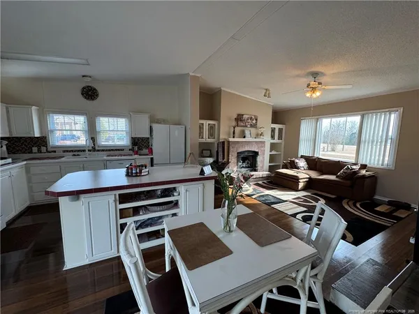 a view of a dining room with furniture a kitchen and chandelier