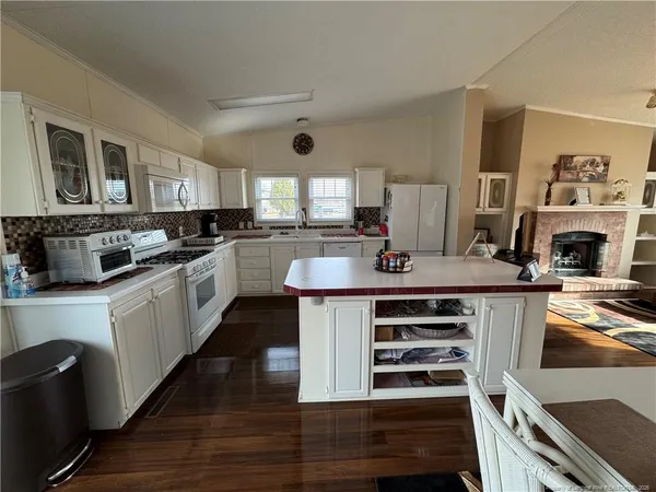 a large kitchen with stainless steel appliances a stove a sink dishwasher and cabinets with wooden floor
