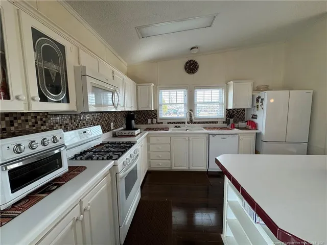 a kitchen with a stove a sink and a microwave