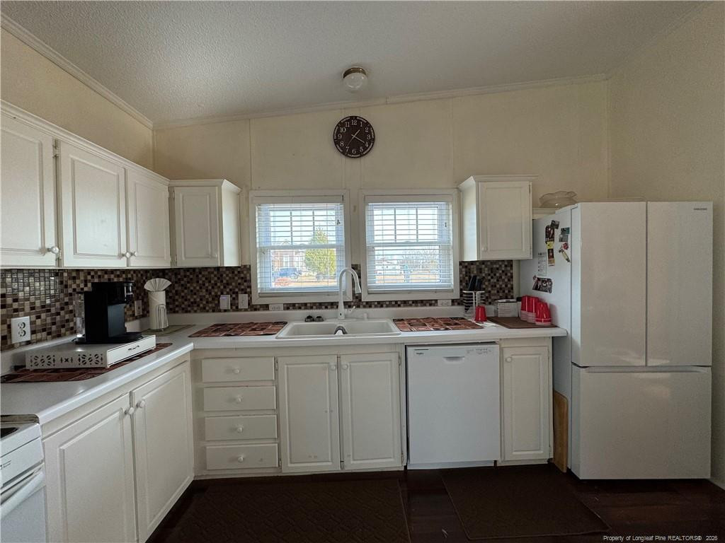 100 L Wallace McClean Road Raeford, NC 28376 - Photo 25 of 38 a kitchen with a sink a refrigerator a window and cabinets