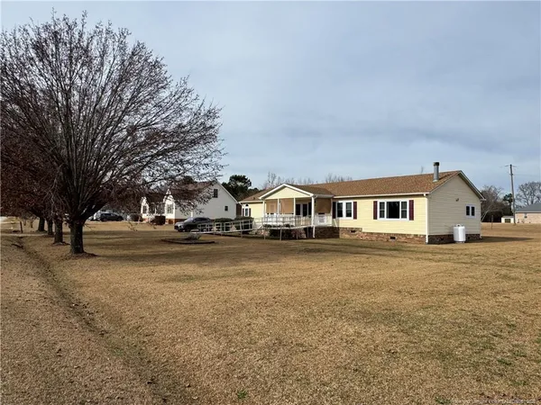 a front view of a house with a yard and trees