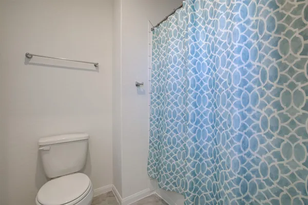 a white toilet sitting next to a white wall