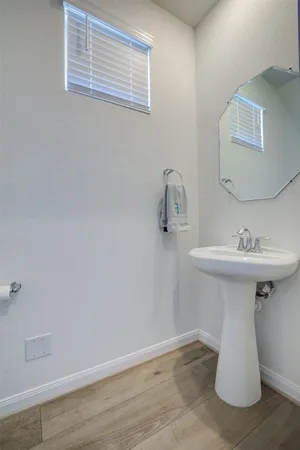 a white sink sitting under a bathroom mirror